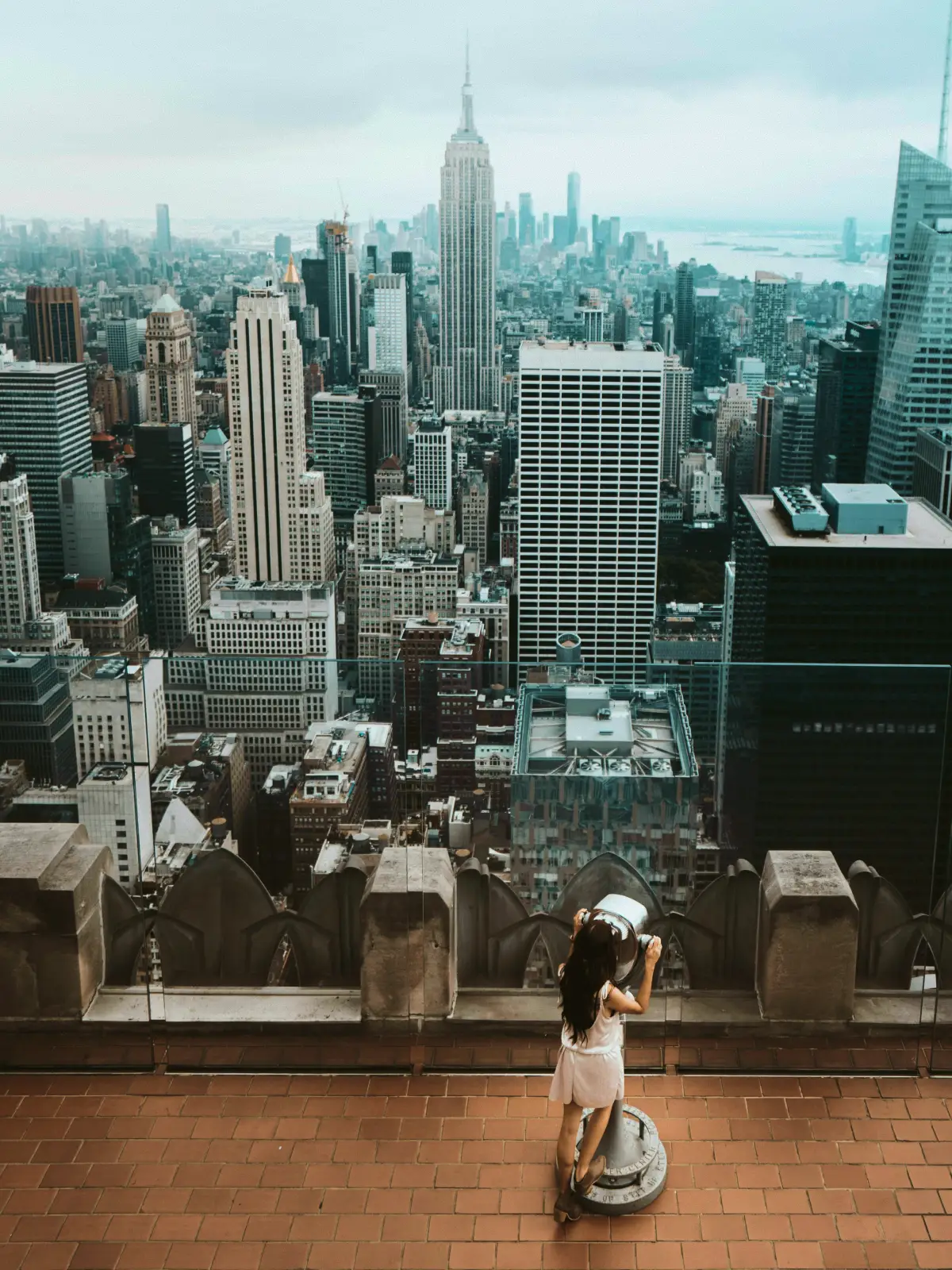 A visitor at a Tower Optical viewer above the Manhattan skyline