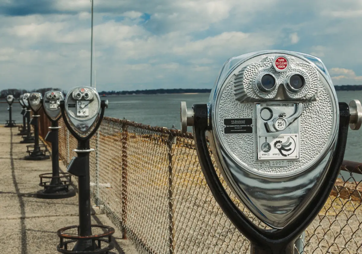 A Tower Optical industrial heavy-duty outdoor binocular viewer looking out across the water