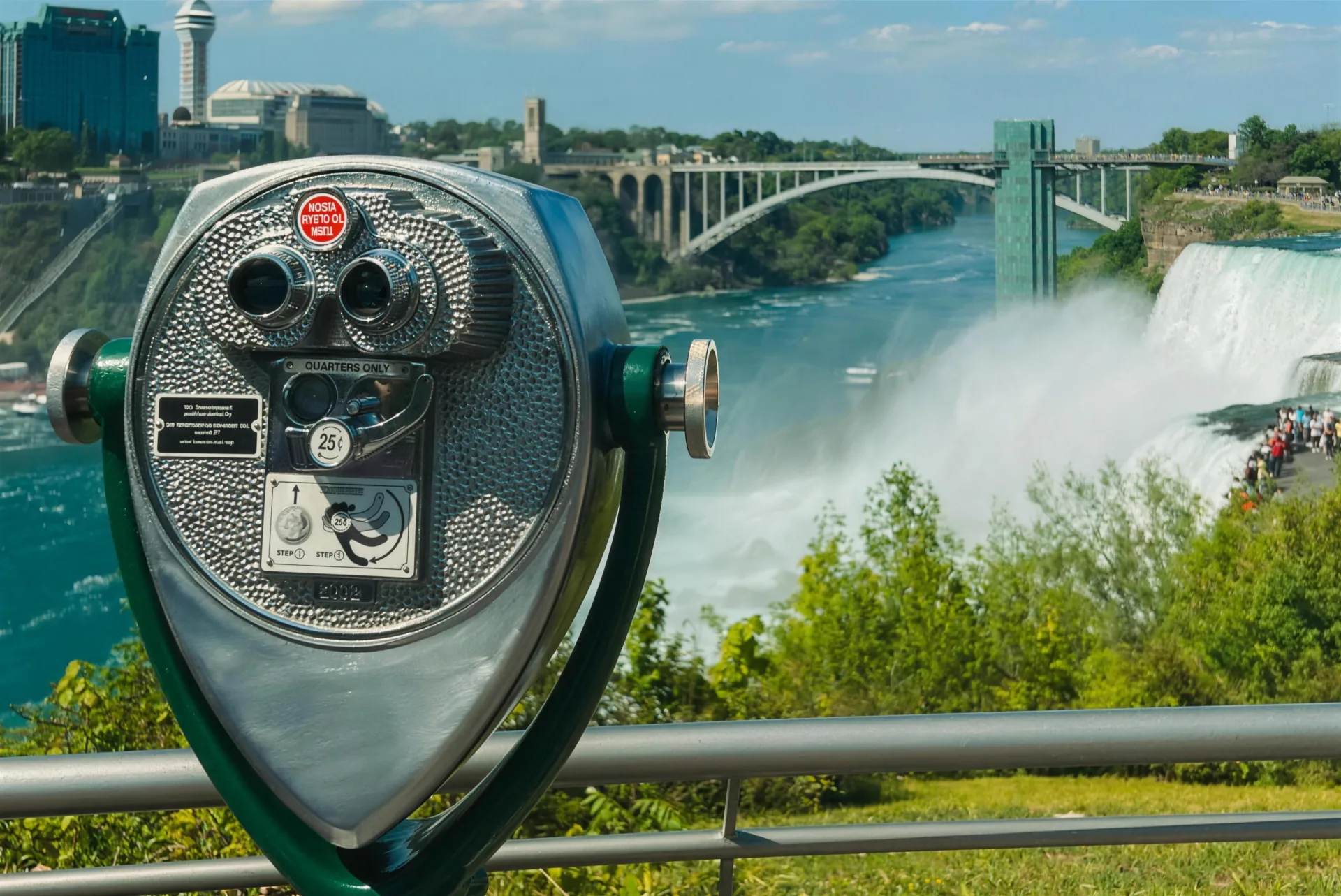 A Tower Optical coin-operated binocular viewer overlooking Niagara Falls, with the Rainbow Bridge behind