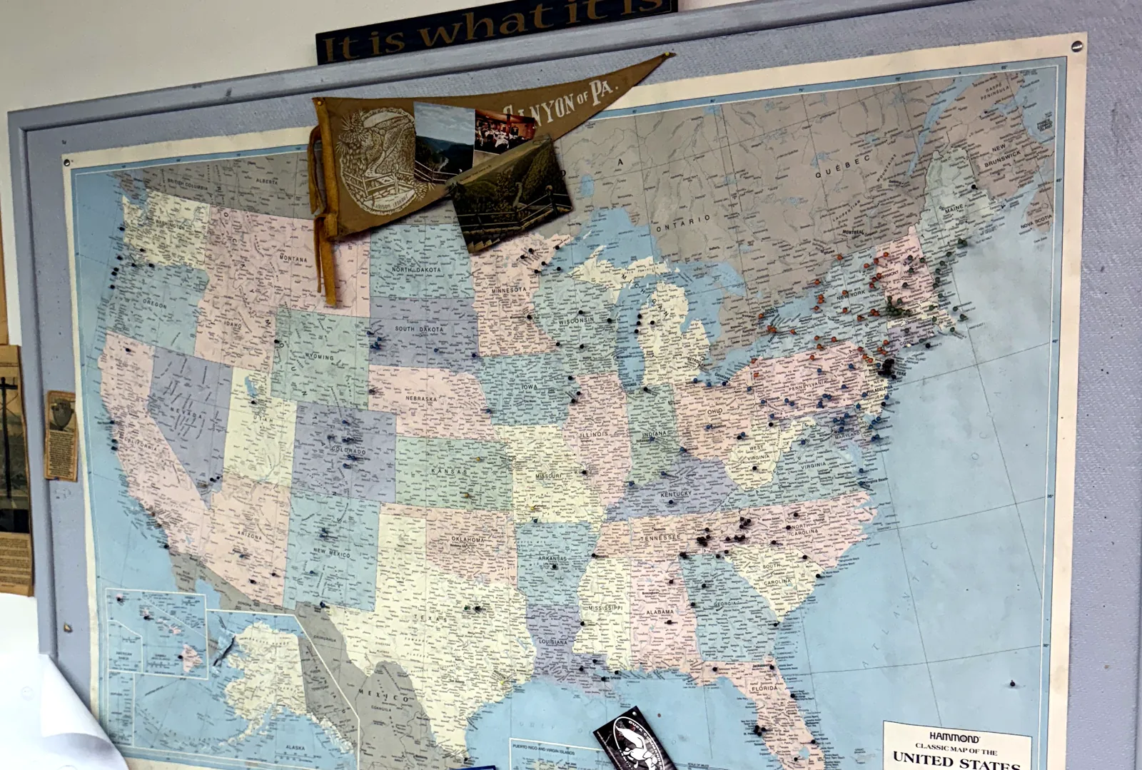 A wall map of the United States in the Norwalk office, covered in pushpins marking viewer placements